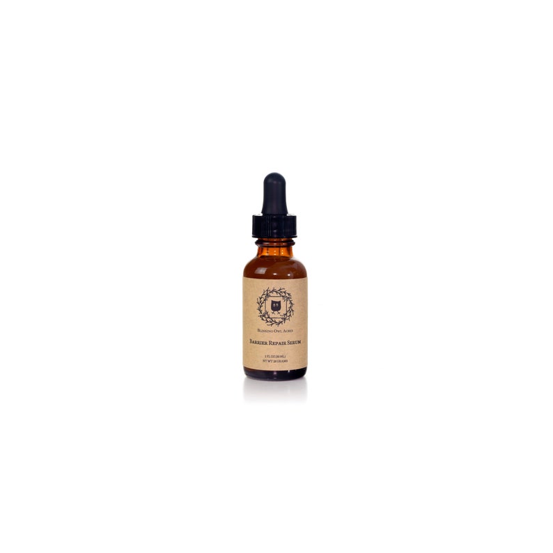 May include: A brown glass bottle with a black dropper top. The bottle is labeled "Rooted Owl Alchemy" and "Barrier Repair Serum".