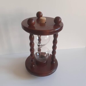 May include: A white ceramic mug with a black handle and the text "But First, Coffee" in a bold, black font. The mug is placed on a white surface, giving a clean, minimalist look.