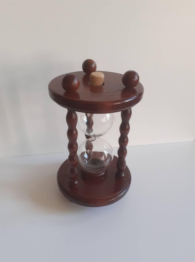 May include: A white ceramic mug with a black handle and the text "But First, Coffee" in a bold, black font. The mug is placed on a white surface, giving a clean, minimalist look.