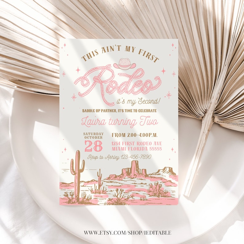May include: A pink and gold invitation for a second birthday party with a western theme. The invitation says "This ain't my first Rodeo! It's my second!" and features a pink cowboy hat and lasso. The invitation also includes the date, time, and location of the party.