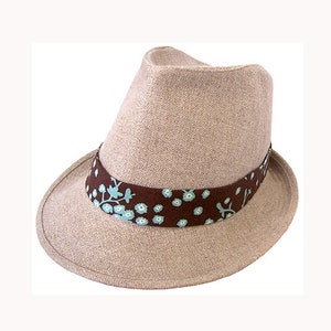 May include: A beige fedora hat with a brown and blue patterned band.