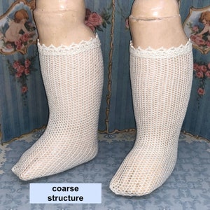 May include: A pair of white crocheted stockings with a coarse structure and a lace trim at the top.