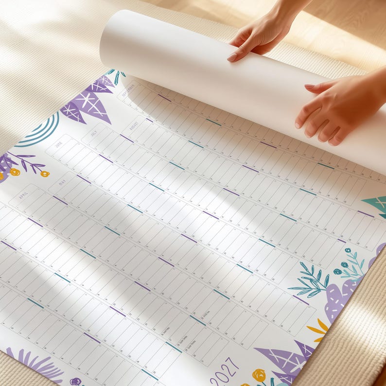 Puede incluir: Un calendario de pared grande, blanco y desplegado para el a&ntilde;o 2027. El calendario presenta un dise&ntilde;o de cuadr&iacute;cula con columnas para los meses y filas para los d&iacute;as. Est&aacute; decorado con ilustraciones estilizadas de flores y hojas en morado, amarillo y verde azulado.