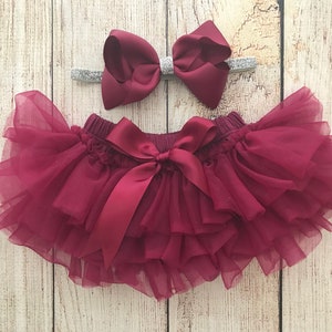 May include: Burgundy tulle baby bloomers with a satin bow and a matching burgundy bow headband with silver glitter.