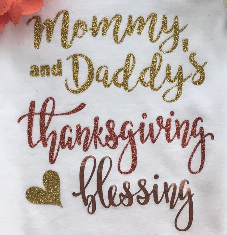 Peut inclure: Une grenouill&egrave;re blanche avec l'inscription "Mommy and Daddy's Thanksgiving Blessing" en lettres paillet&eacute;es dor&eacute;es et un c&oelig;ur paillet&eacute; dor&eacute;.