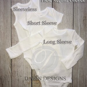 May include: Three white onesies, one sleeveless, one short sleeve, and one long sleeve. The onesies are stacked on top of each other. The text "Also Available in: These Regular Onesies" is at the top of the image. The text "Sleeveless", "Short Sleeve", and "Long Sleeve" are written on the onesies. The text "Dabin Designs" is at the bottom of the image.