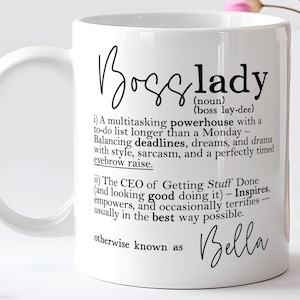 May include: A white ceramic mug featuring black printed text that defines the term Boss lady as a multitasking powerhouse. The text includes a phonetic pronunciation, a humorous definition, and the name Bella at the bottom in script font.