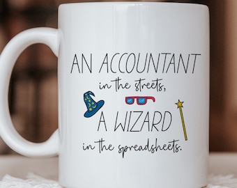 Może przedstawiać: Biały ceramiczny kubek z czarnym napisem "AN ACCOUNTANT in the streets, A WIZARD in the spreadsheets." Wzór zawiera niebieski kapelusz czarodzieja z żółtymi gwiazdkami, okulary w czerwonych oprawkach oraz żółtą magiczną różdżkę.