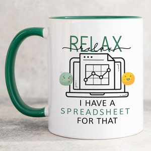 Op de afbeelding: Een witte keramische mok met een donkergroen handvat en binnenrand. De voorzijde toont een afbeelding van een laptop met een spreadsheet, geflankeerd door twee kleine ronde gezichtjes, met de tekst RELAX en I HAVE A SPREADSHEET FOR THAT.