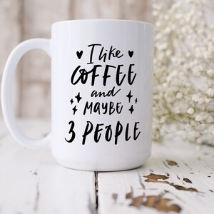 May include: White ceramic coffee mug with black text that reads "I like coffee and maybe 3 people".