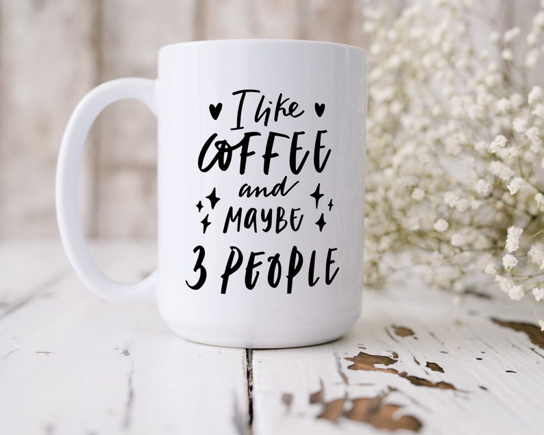 May include: White ceramic coffee mug with black text that reads "I like coffee and maybe 3 people".