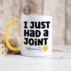 May include: A white ceramic mug with a bright yellow handle and interior. The front features bold black text that reads I JUST HAD a JOINT (replacement) followed by a small yellow winking smiley face icon printed on the surface.