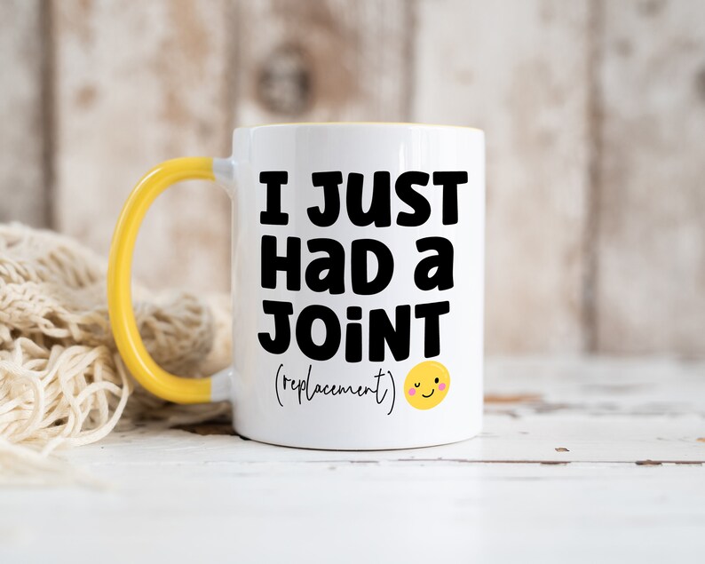 May include: A white ceramic mug with a bright yellow handle and interior. The front features bold black text that reads I JUST HAD a JOINT (replacement) followed by a small yellow winking smiley face icon printed on the surface.