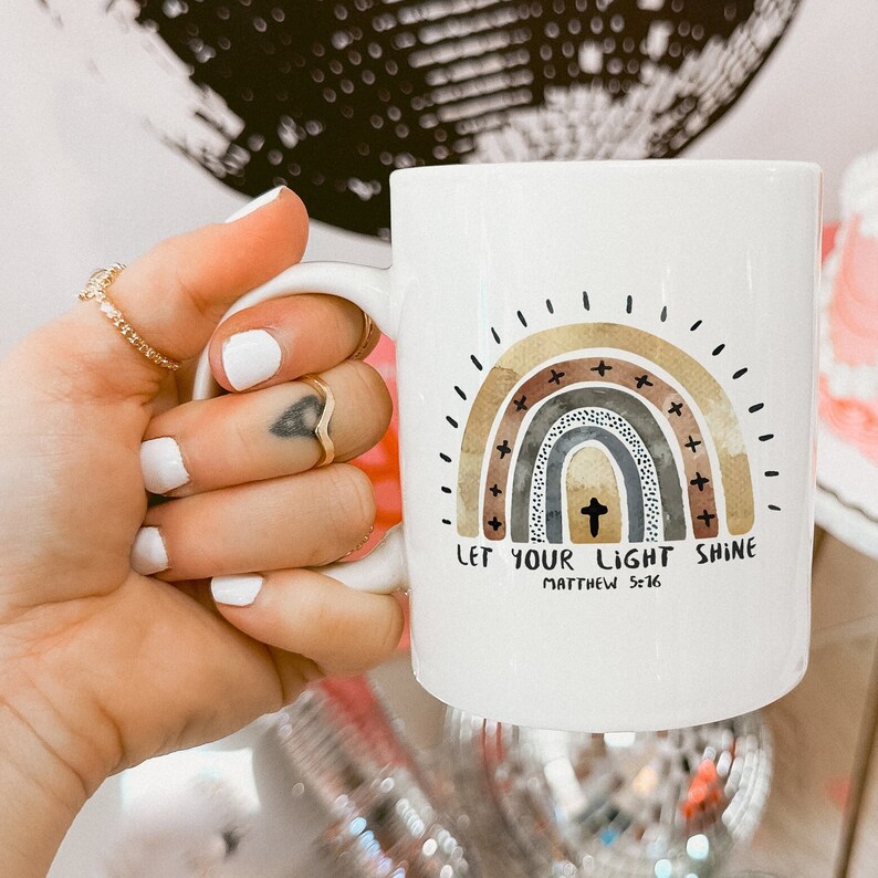 May include: White ceramic mug with a rainbow design and the text "Let your light shine Matthew 5:16".