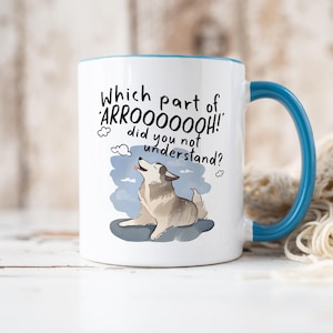 May include: A white ceramic mug with a blue handle and interior rim. The mug features a graphic of a howling dog and the black text: Which part of 'ARROOOOOOH!' did you not understand? The design includes small cloud icons around the text.