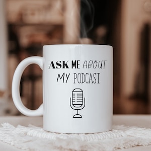 May include: White ceramic mug with a black graphic that says "Ask me about my podcast" and a microphone icon.