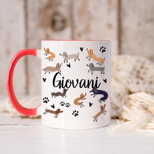 Pode incluir: Uma caneca de cer&acirc;mica branca com uma pega e rebordo interior vermelho brilhante. O exterior apresenta um padr&atilde;o repetitivo de pequenos c&atilde;es dachshund desenhados &agrave; m&atilde;o em v&aacute;rios tons de castanho, cinzento e preto, intercalados com cora&ccedil;&otilde;es e pegadas pretas. O nome Giovani est&aacute; impresso em letra cursiva preta no centro.