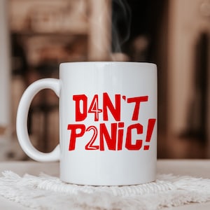 May include: White ceramic mug with a red graphic that says "Don't P2nic!"