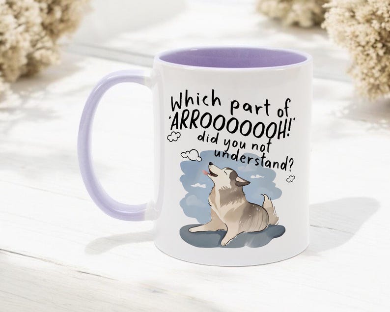 May include: A white ceramic mug with a light purple interior and handle. The front features a cartoon illustration of a howling husky dog and the black text: Which part of 'ARROOOOOOH!' did you not understand? The design includes small cloud accents.