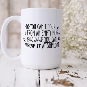 May include: White ceramic mug with a large handle. The mug features black text that reads, "YOU CAN'T POUR FROM AN EMPTY MUG. HOWEVER YOU CAN THROW IT AT SOMEONE."