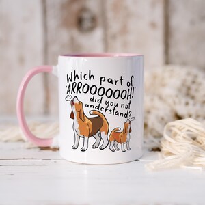 a ceramic mug featuring the phrase 'which part of 'arrooooo!' did you not understand? surrounding an illustration of two beagles howling.