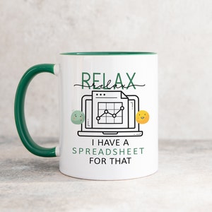 Puede incluir: Taza de cerámica blanca con borde y asa verdes. La taza tiene una ilustración en blanco y negro de un portátil con una hoja de cálculo y un gráfico. El texto "Relax" está escrito en cursiva sobre el portátil. Debajo del portátil, el texto dice "Tengo una hoja de cálculo para eso".