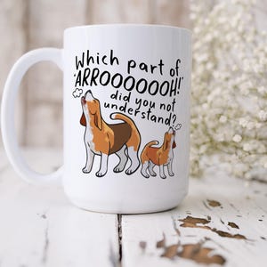 a ceramic mug featuring the phrase 'which part of 'arrooooo!' did you not understand? surrounding an illustration of two beagles howling.