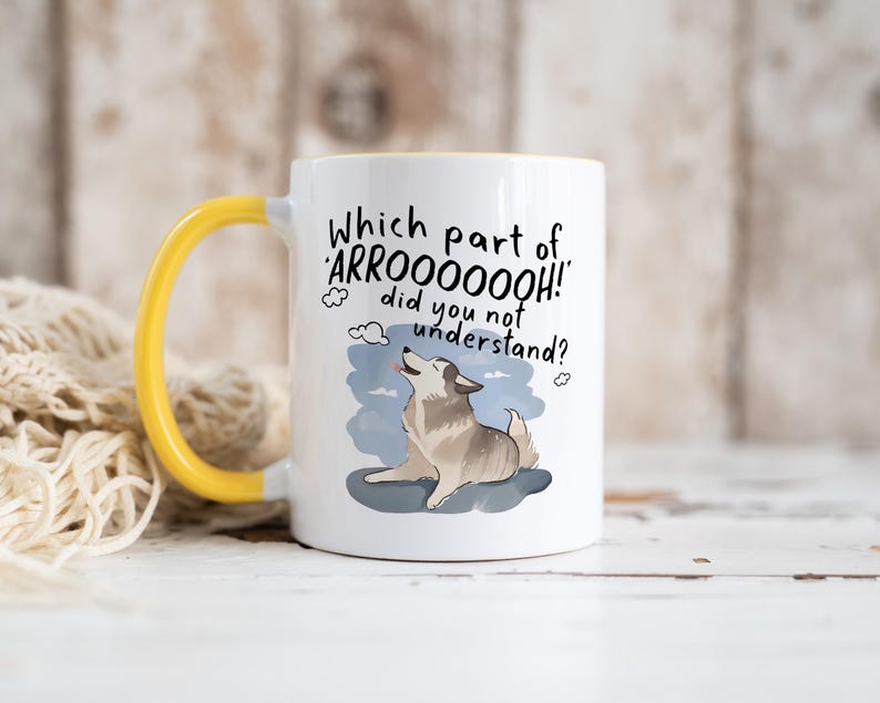 May include: A white ceramic mug with a bright yellow handle and interior. The front features a graphic of a howling husky dog on a blue patch with the black text: Which part of 'ARROOOOOOH!' did you not understand? The design includes small cloud icons.