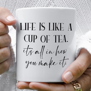 May include: White ceramic mug with black text that reads "LIFE IS LIKE A CUP OF TEA. it's all in how you make it."