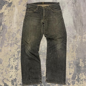 Pu&ograve; includere: Jeans in denim grigio scuro con un aspetto sbiadito. I jeans hanno un classico design a cinque tasche, una chiusura con bottone e cerniera e un taglio dritto. Il tessuto mostra segni di usura, conferendo loro un aspetto vintage.