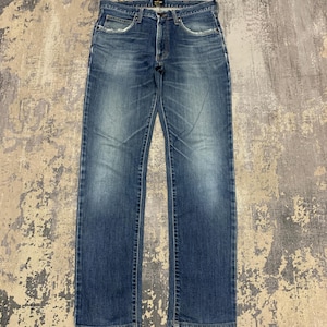 May include: Blue denim jeans with a faded wash and a classic five-pocket design. The jeans have a straight leg cut and a button and zipper closure. The Wrangler brand name is visible on the back pocket.