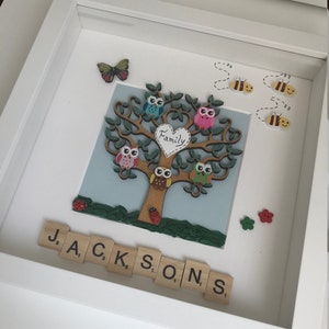 May include: A framed artwork featuring a tree with owls and a heart that says "Family". The tree is surrounded by bees and ladybugs. The name "JACKSON" is spelled out below the tree using letter tiles.