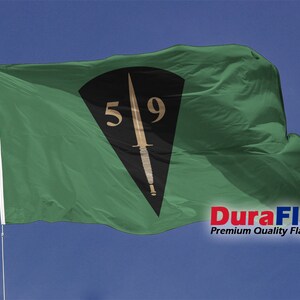 May include: A green flag with a black emblem featuring a dagger and the numbers "59". The flag is waving in the wind against a blue sky. The text "DuraFlag" is visible in the bottom right corner.