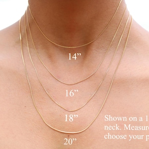 May include: Four gold chain necklaces of different lengths, 14 inches, 16 inches, 18 inches, and 20 inches, shown on a model's neck. The text "Shown on a 12.5" neck. Measure yours to choose your perfect fit!" is displayed below the necklaces.