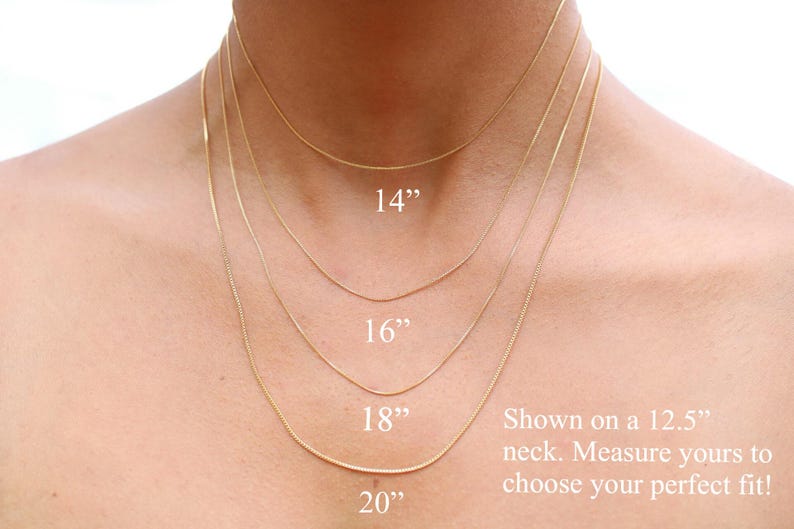 May include: Four gold chain necklaces of different lengths, 14 inches, 16 inches, 18 inches, and 20 inches, shown on a model's neck. The text "Shown on a 12.5" neck. Measure yours to choose your perfect fit!" is displayed below the necklaces.