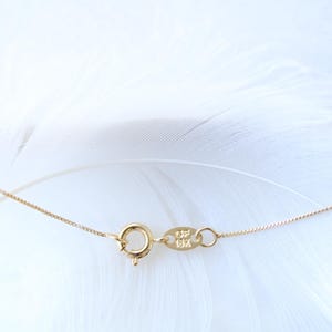 May include: A gold chain necklace with a lobster clasp and a small tag with the inscription "925" on it.