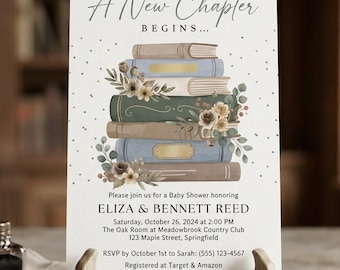 May include: A white rectangular baby shower invitation card featuring a stack of illustrated books in blue, green, and tan with floral accents. The text reads A New Chapter BEGINS, Eliza & Bennett Reed, and event details for 26 October 2024.