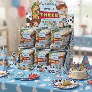 May include: A festive birthday party scene featuring a display of snack bags with Toy Story characters. The display reads "THREE" and "Jayden's 3rd Bday". Party hats, plates, and a cake with figurines complete the celebratory theme.