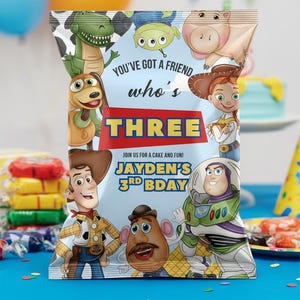 May include: A colorful party favor bag featuring characters from the Toy Story movie. The bag has the text "YOU'VE GOT A FRIEND who's THREE" and "JAYDEN'S 3RD BDAY". The bag is decorated with images of Woody, Buzz Lightyear, and other characters.