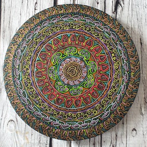 Pode incluir: Um mandala circular de madeira com padr&otilde;es intrincados em tons de marrom, vermelho, verde, amarelo e branco. O mandala &eacute; pintado em um fundo preto e tem um design de c&iacute;rculo conc&ecirc;ntrico.