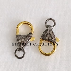 Può includere: Due chiusure a moschettone in argento e oro con accenti di diamanti pavé. Le chiusure sono lunghe circa 2,5 cm.