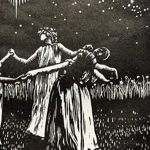 A detail shot of a Black and white art print depicting a celestial scene. A crescent moon with radiating lines is centered above 5 female figures in flowing robes, holding hands in a circle. The background is a starry night sky, with a field of tall grass in the foreground.
