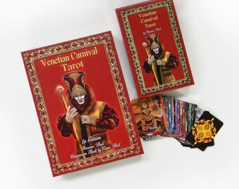 May include: A red box with gold trim and a gold ornate border. The box contains a deck of Venetian Carnival Tarot cards. The box has the text "Venetian Carnival Tarot" and "1st Edition" on the front. The text "Companion Book by Victor Paul" is also on the front of the box.