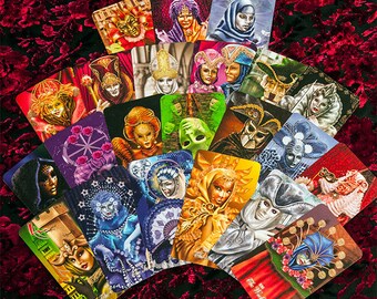 May include: A set of 22 tarot cards featuring colorful illustrations of masked figures in various poses. The cards are arranged in a fan shape on a red velvet background.
