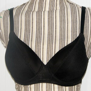 May include: A black bra with adjustable straps. The bra has a smooth, seamless cup and a lace trim.