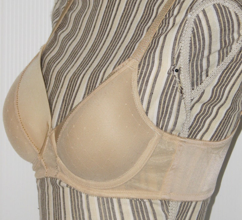 May include: A beige underwire bra with adjustable straps and a smooth, seamless cup.