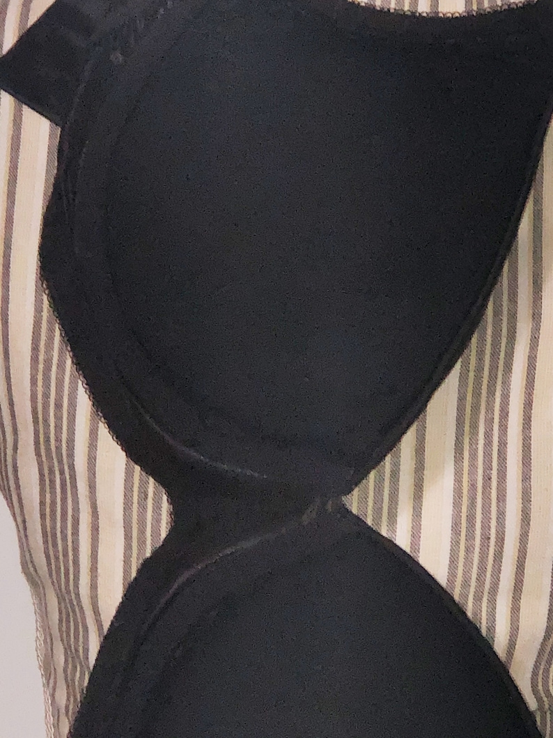 May include: Black undergarment with a smooth, seamless design. The undergarment is made of a soft, stretchy fabric and has a comfortable fit.