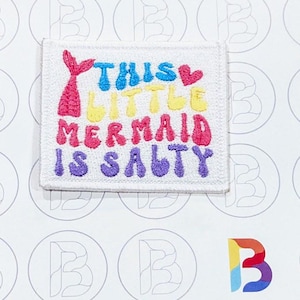 May include: White embroidered patch with a rainbow mermaid tail and the text "This Little Mermaid Is Salty".