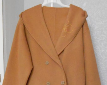 May include: A long, brown wool coat with a double-breasted closure and a large hood. The coat has a subtle embroidered design on the hood and a stitched detail along the front.