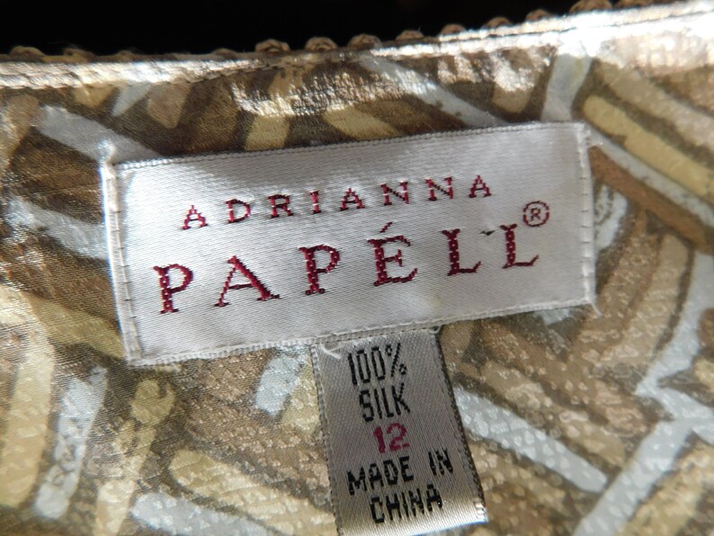 May include: A white tag with red text that reads "Adrianna Papell&reg;" and a smaller white tag with black text that reads "100% Silk 12 Made in China".